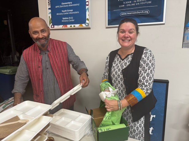A person and person standing next to a tray of food  AI-generated content may be incorrect.