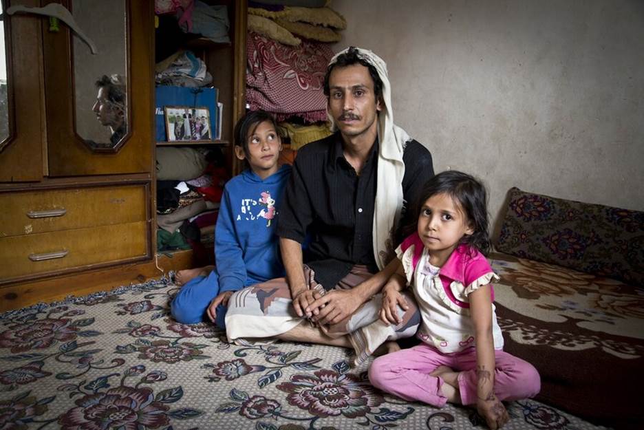 A person and two children sitting on a bed Description automatically generated with medium confidence