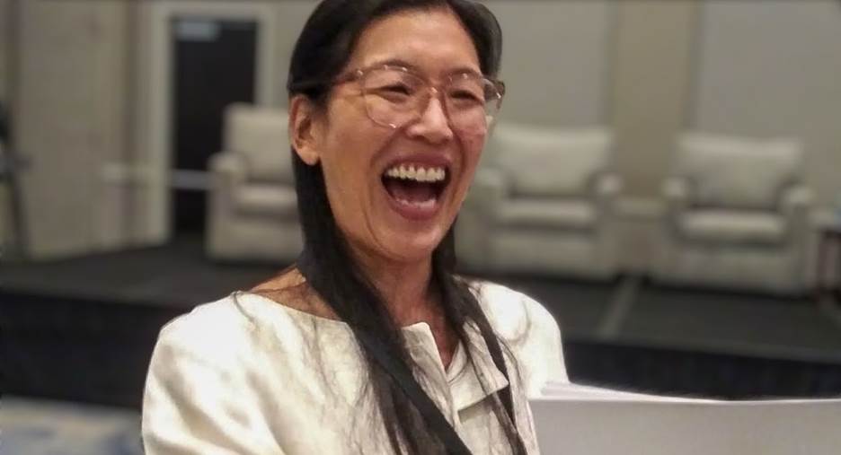 A person laughing with her mouth open Description automatically generated