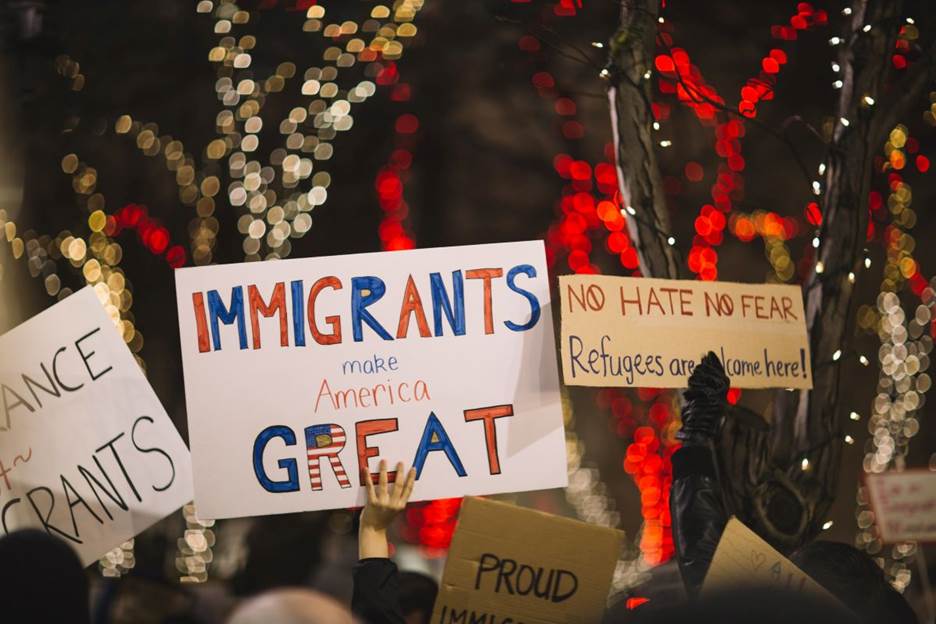 A group of people holding signs Description automatically generated