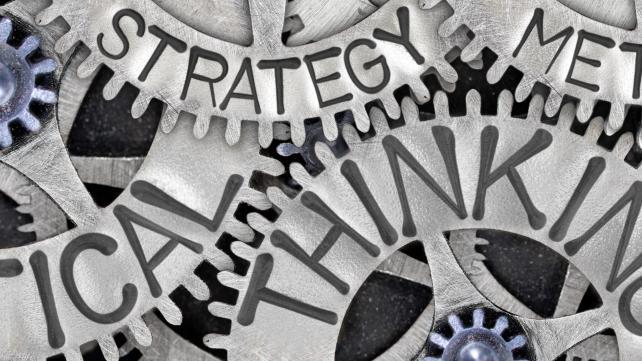 Close-up of gears with words Description automatically generated