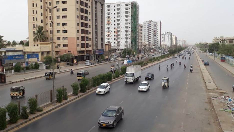 A road with cars and buildings Description automatically generated
