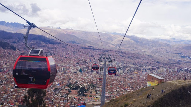A cable car going over a city Description automatically generated