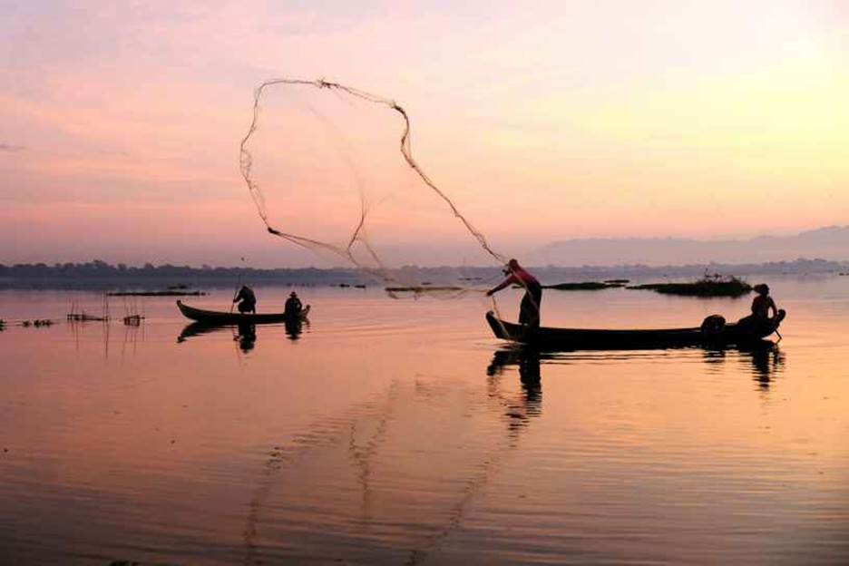 A group of people fishing on a lake Description automatically generated