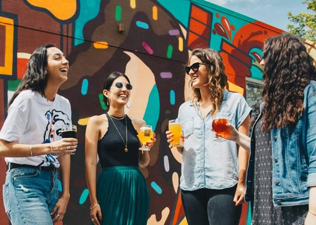A group of women holding drinks  Description automatically generated