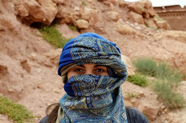 A person with a scarf over her face  AI-generated content may be incorrect.
