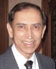 A person in a suit and tie smiling Description automatically generated