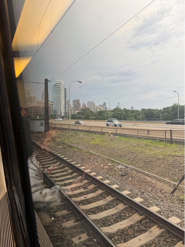 Train tracks with a city in the background  AI-generated content may be incorrect.