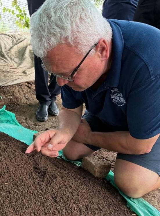 A person kneeling down on dirt  AI-generated content may be incorrect.