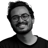 A person wearing glasses smiling  AI-generated content may be incorrect.